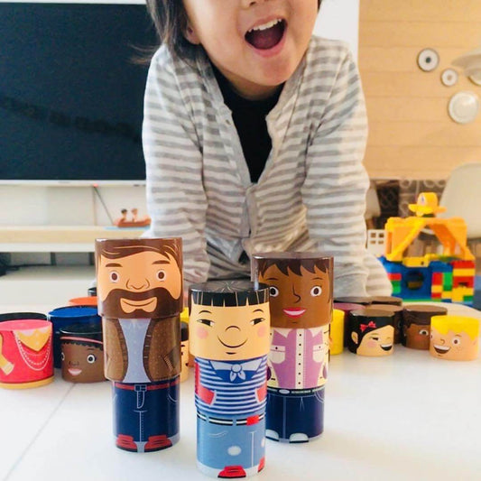 Smiling child playing with magnetic wooden family figures