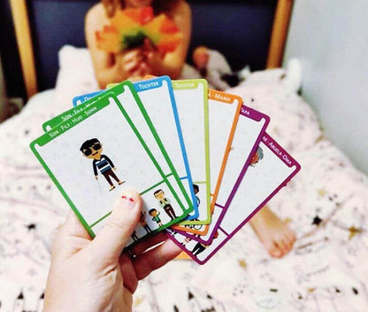 Player holding a selection of colorful character cards from the Happy Family Card Game, showcasing family diversity.